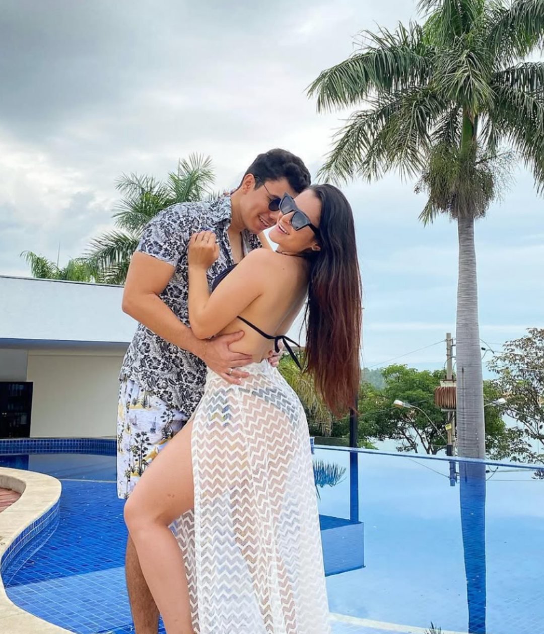 Casal se abraçando à beira da piscina